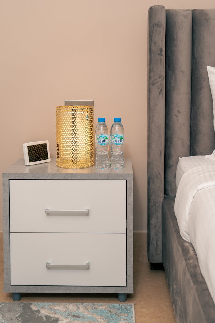 The Art of Drawing Readers In: Your attractive post title goes here Stylish nightstand setup in a Dubai hotel room featuring a lamp, water bottles, and neat decor.